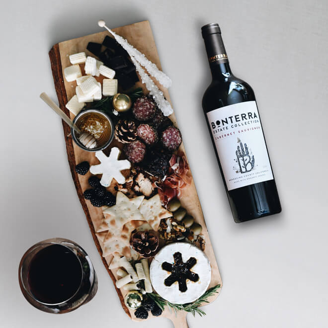 grazing board featuring a selection of star shaped crackers, sausages, and cheeses