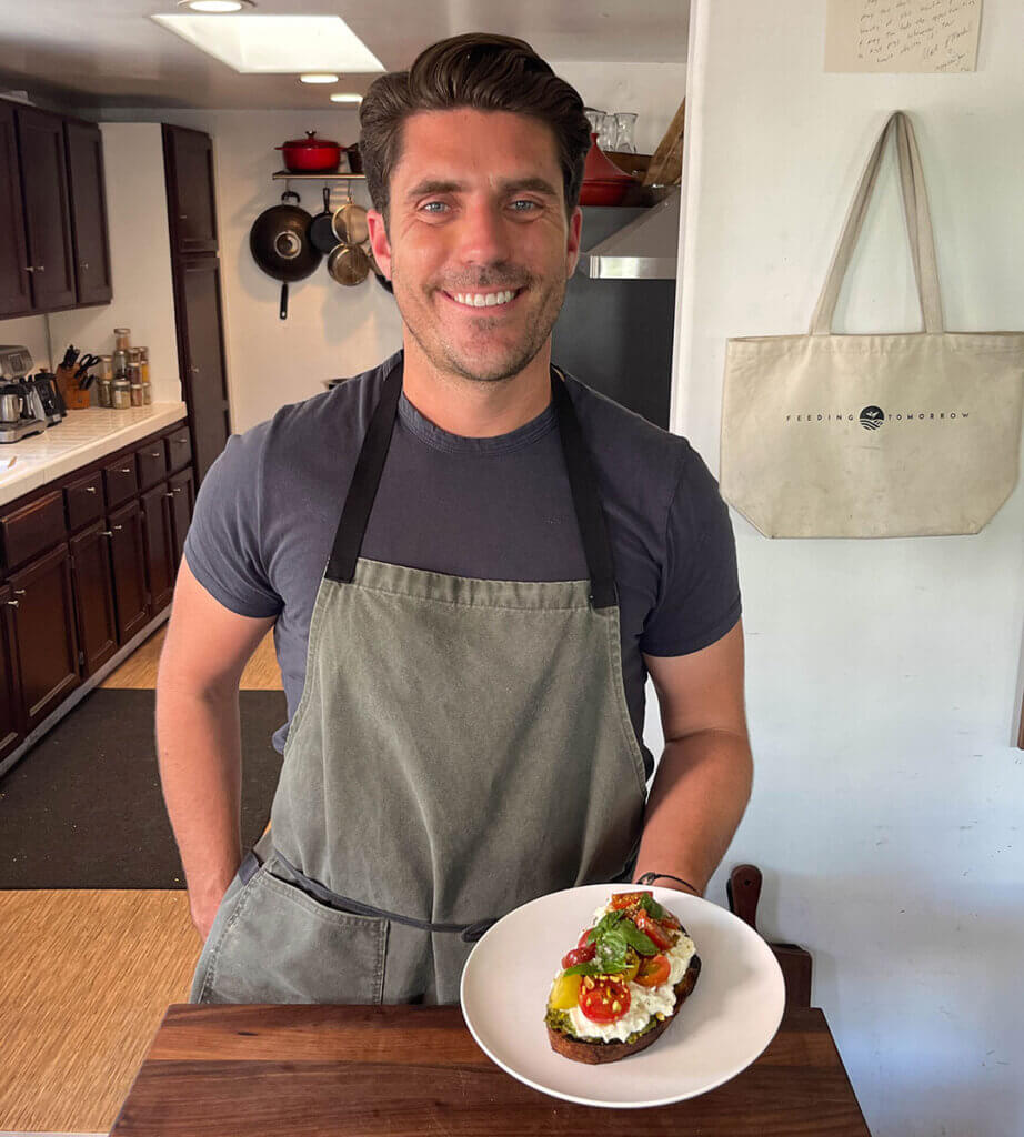 Oliver English holding the Heirloom Tomato & Burrata Summer Toast recipe he created to pair with our Estate Cabernet